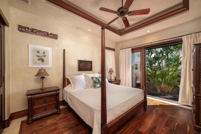 bedroom with access to exterior, ceiling fan, dark hardwood / wood-style floors, a tray ceiling, and ornamental molding