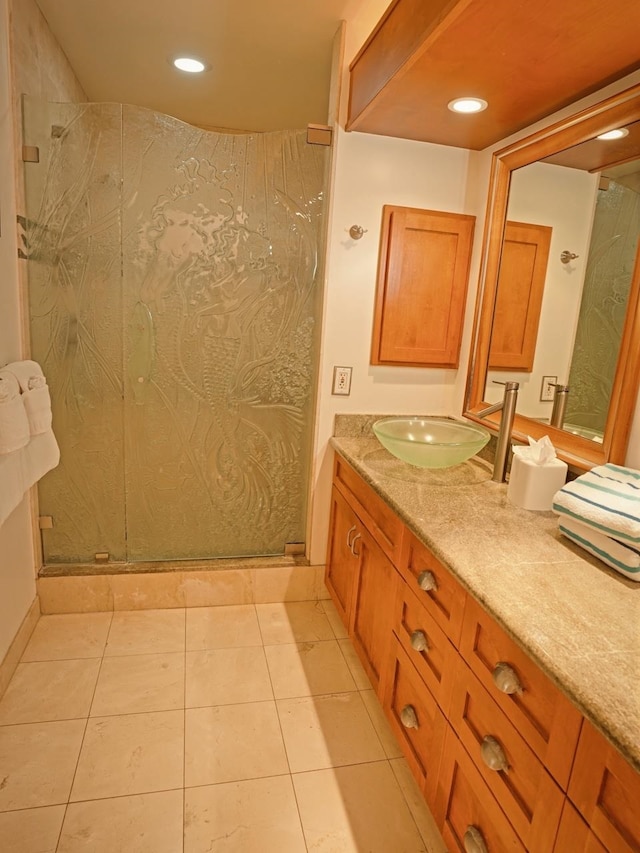 bathroom with a shower with shower door, vanity, and tile floors