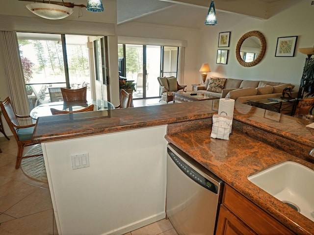 kitchen with a healthy amount of sunlight, dark stone counters, dishwasher, and light tile floors