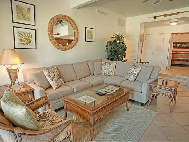 living room with tile flooring, ceiling fan, and beam ceiling