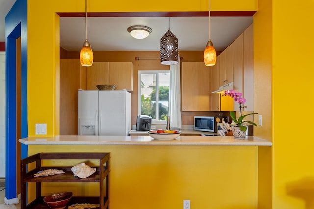 kitchen with pendant lighting and white fridge with ice dispenser