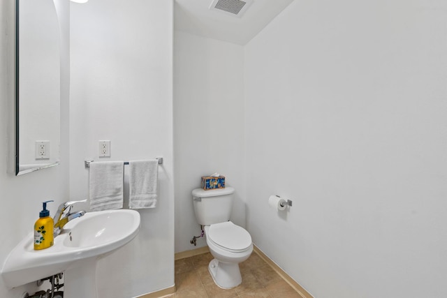 bathroom featuring sink, toilet, and tile patterned flooring