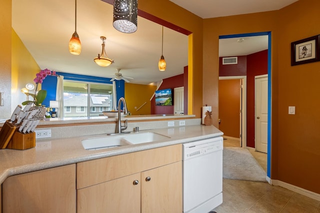 kitchen featuring white dishwasher, decorative light fixtures, light brown cabinets, and sink