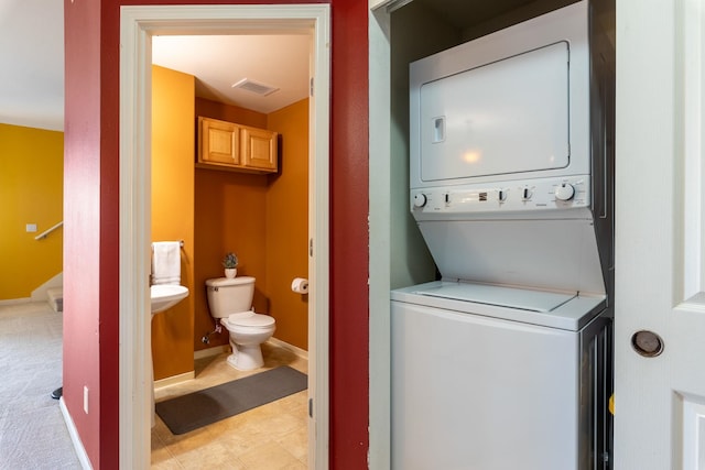 washroom with light carpet and stacked washer / drying machine