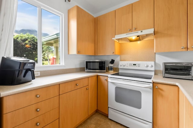 kitchen with white electric range oven and light tile patterned floors