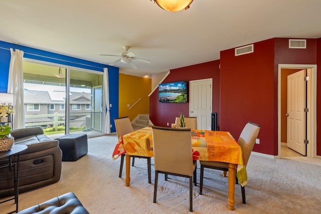 carpeted dining area with ceiling fan