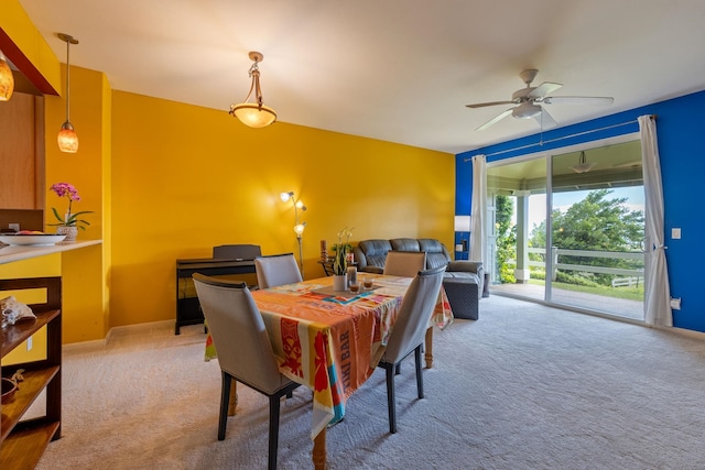 carpeted dining room featuring ceiling fan