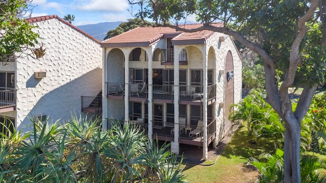 back of house featuring a mountain view and a balcony