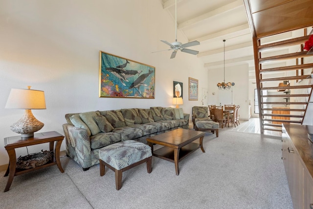 living room with beam ceiling, ceiling fan, and a high ceiling