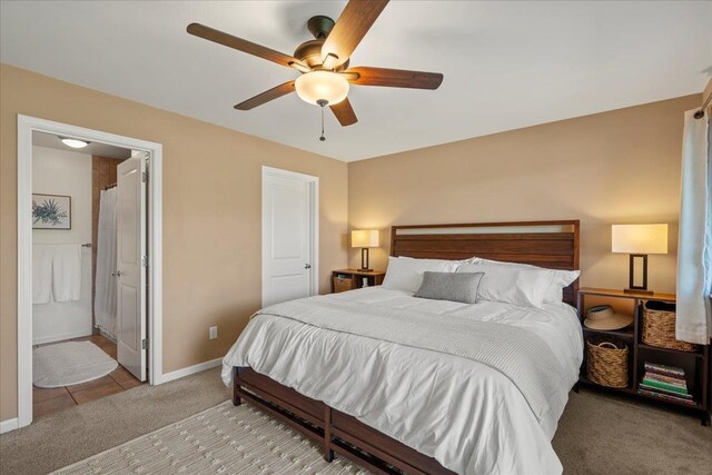 bedroom featuring baseboards, ceiling fan, light carpet, and connected bathroom