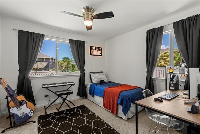 carpeted bedroom with multiple windows and a ceiling fan