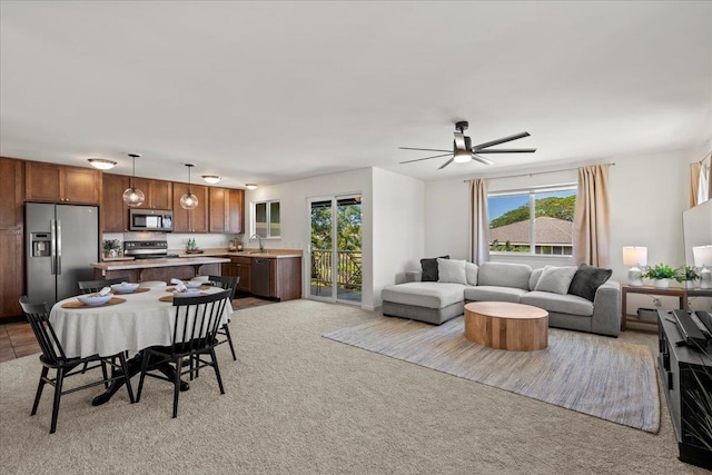 living area with ceiling fan and light colored carpet
