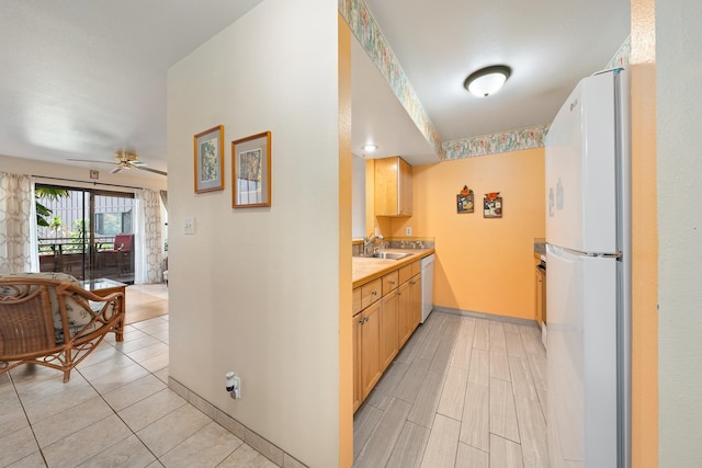 kitchen featuring sink, white appliances, ceiling fan, light tile patterned flooring, and light brown cabinetry