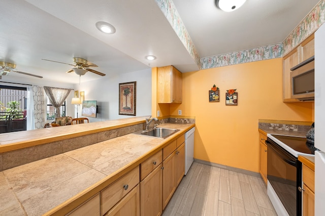 kitchen featuring ceiling fan, sink, kitchen peninsula, and white appliances