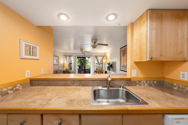 kitchen with sink, light brown cabinetry, ceiling fan, and kitchen peninsula