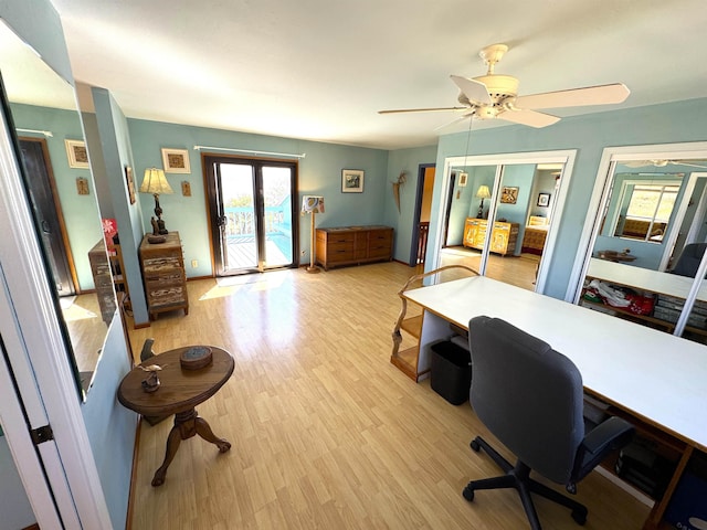 home office with ceiling fan, french doors, and light hardwood / wood-style floors