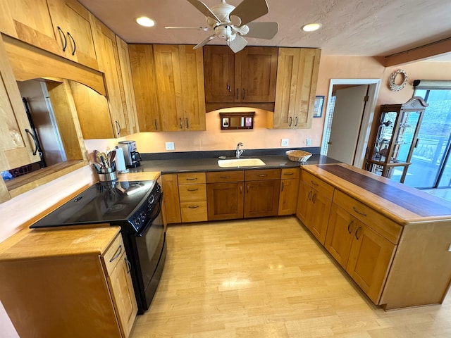 kitchen with wood counters, ceiling fan, sink, electric range, and light hardwood / wood-style floors