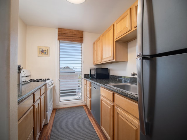 kitchen featuring sink, appliances with stainless steel finishes, light brown cabinets, and dark wood-type flooring