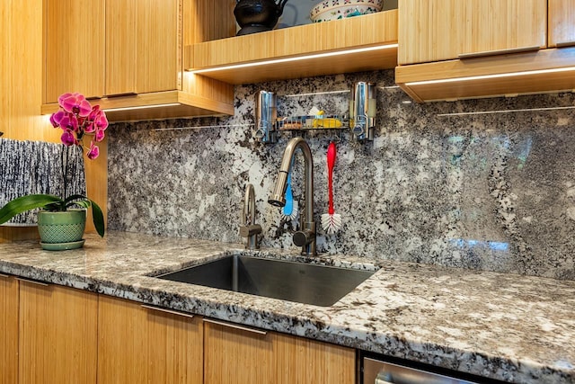 kitchen featuring sink, tasteful backsplash, and stone counters