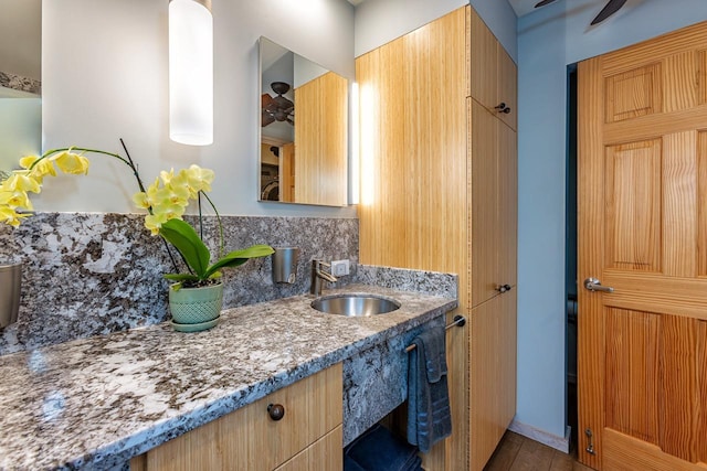 bathroom featuring vanity, ceiling fan, and tasteful backsplash