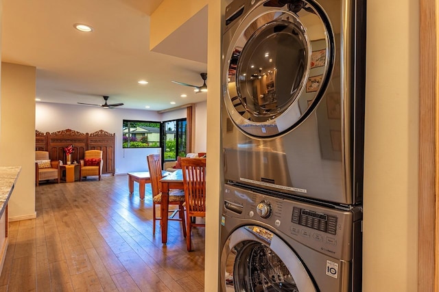 washroom featuring ceiling fan, wood-type flooring, and stacked washer / drying machine