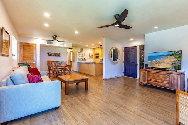 living room featuring light hardwood / wood-style floors and ceiling fan