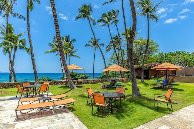 view of property's community featuring a patio, a water view, and a lawn