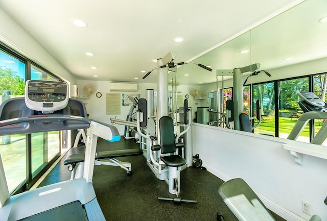 exercise room featuring a wall mounted AC and a wealth of natural light