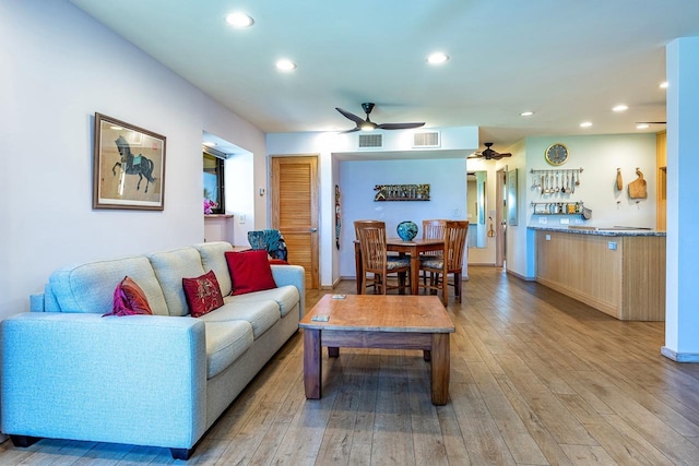 living room with light hardwood / wood-style flooring and ceiling fan