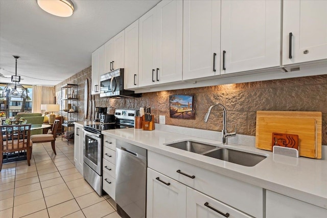 kitchen with white cabinets, sink, tasteful backsplash, and stainless steel appliances