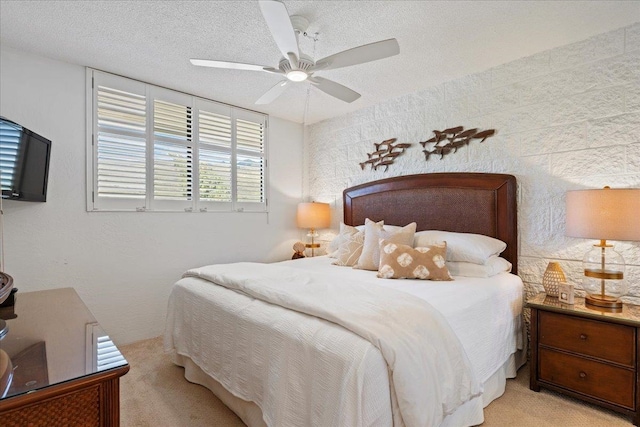 bedroom featuring light carpet, ceiling fan, and a textured ceiling