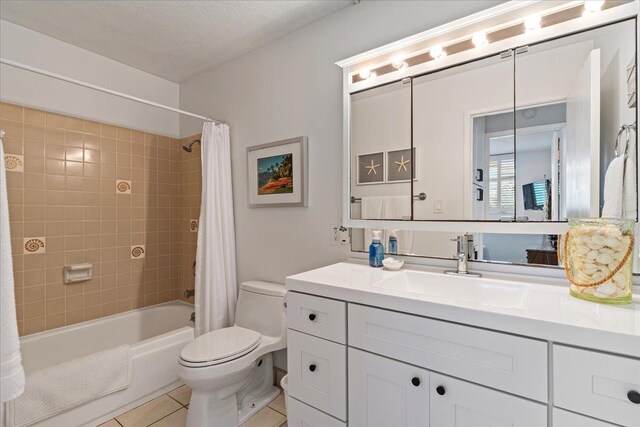 full bathroom featuring tile floors, large vanity, a textured ceiling, shower / tub combo, and toilet