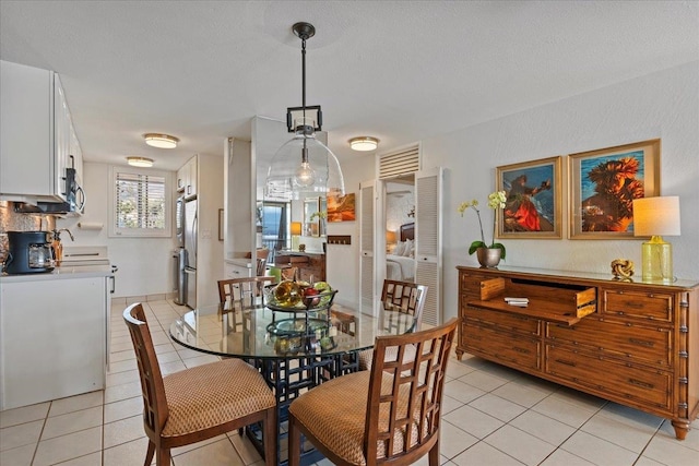 dining space with light tile floors and a textured ceiling