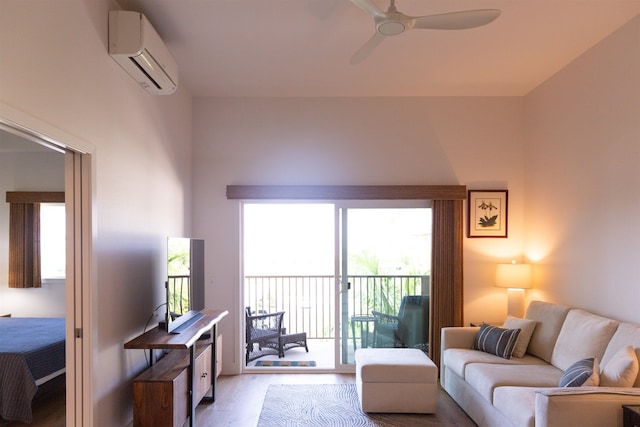 living area with ceiling fan, wood finished floors, and a wall mounted AC