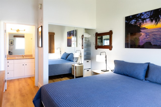 bedroom with a sink, light wood-type flooring, and connected bathroom