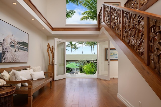 entrance foyer with baseboards, a high ceiling, wood finished floors, and recessed lighting