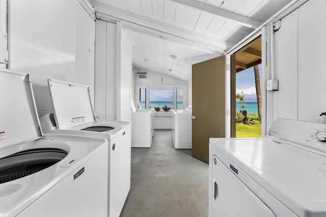 clothes washing area featuring a water view and independent washer and dryer