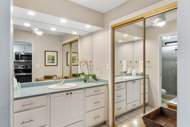 bathroom featuring tile patterned floors, vanity, toilet, and walk in shower