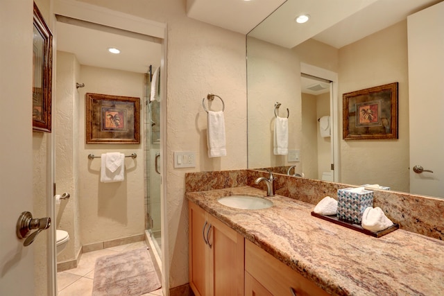 bathroom with tile patterned flooring, a shower with door, toilet, and vanity