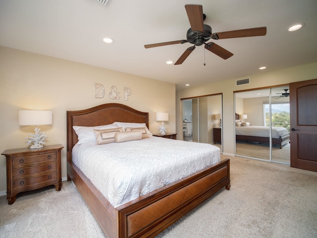 carpeted bedroom with two closets and ceiling fan