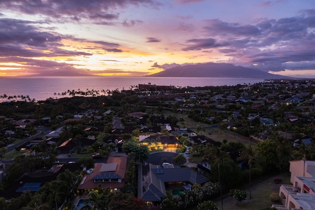 aerial view at dusk featuring a water and mountain view