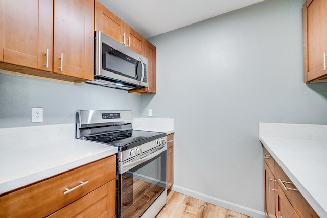 480 Kenolio Rd Unit 22-105, Kihei, HI 96753 - kitchen featuring appliances with stainless steel finishes, light wood finished floors, and light countertops