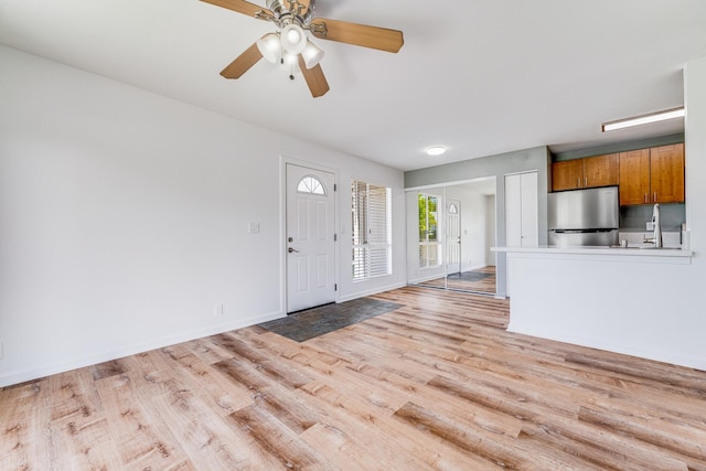 480 Kenolio Rd Unit 22-105, Kihei, HI 96753 - foyer entrance with light wood-style floors and a ceiling fan