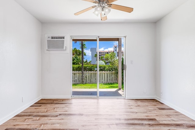 480 Kenolio Rd Unit 22-105, Kihei, HI 96753 - empty room featuring a wall mounted air conditioner, wood finished floors, and a ceiling fan