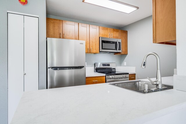 480 Kenolio Rd Unit 22-105, Kihei, HI 96753 - kitchen featuring stainless steel appliances, light countertops, and brown cabinets