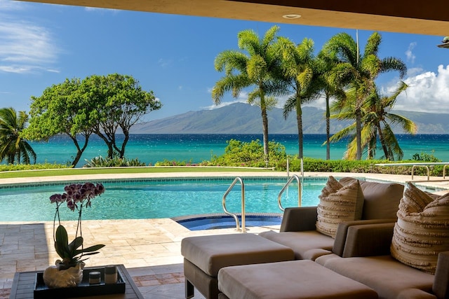 view of pool with a water and mountain view and a patio area