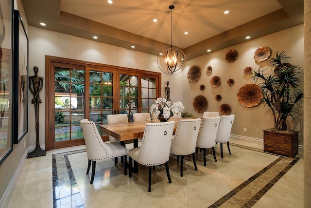 dining area with a tray ceiling and a chandelier