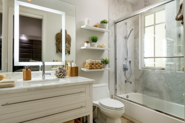 full bathroom featuring bath / shower combo with glass door, vanity, and toilet