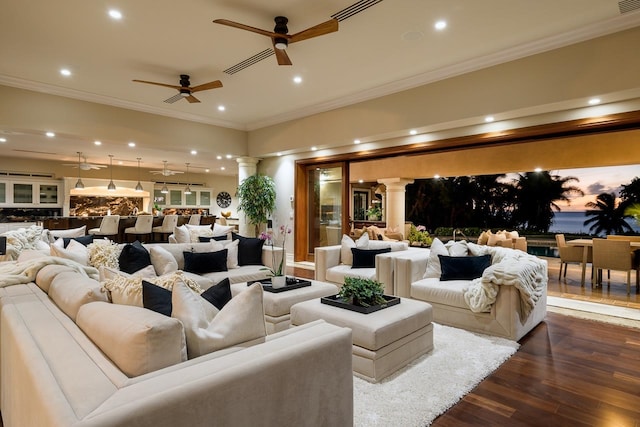 living room with decorative columns, ornamental molding, dark hardwood / wood-style flooring, and ceiling fan