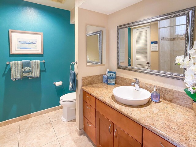 bathroom featuring tile floors, large vanity, and toilet